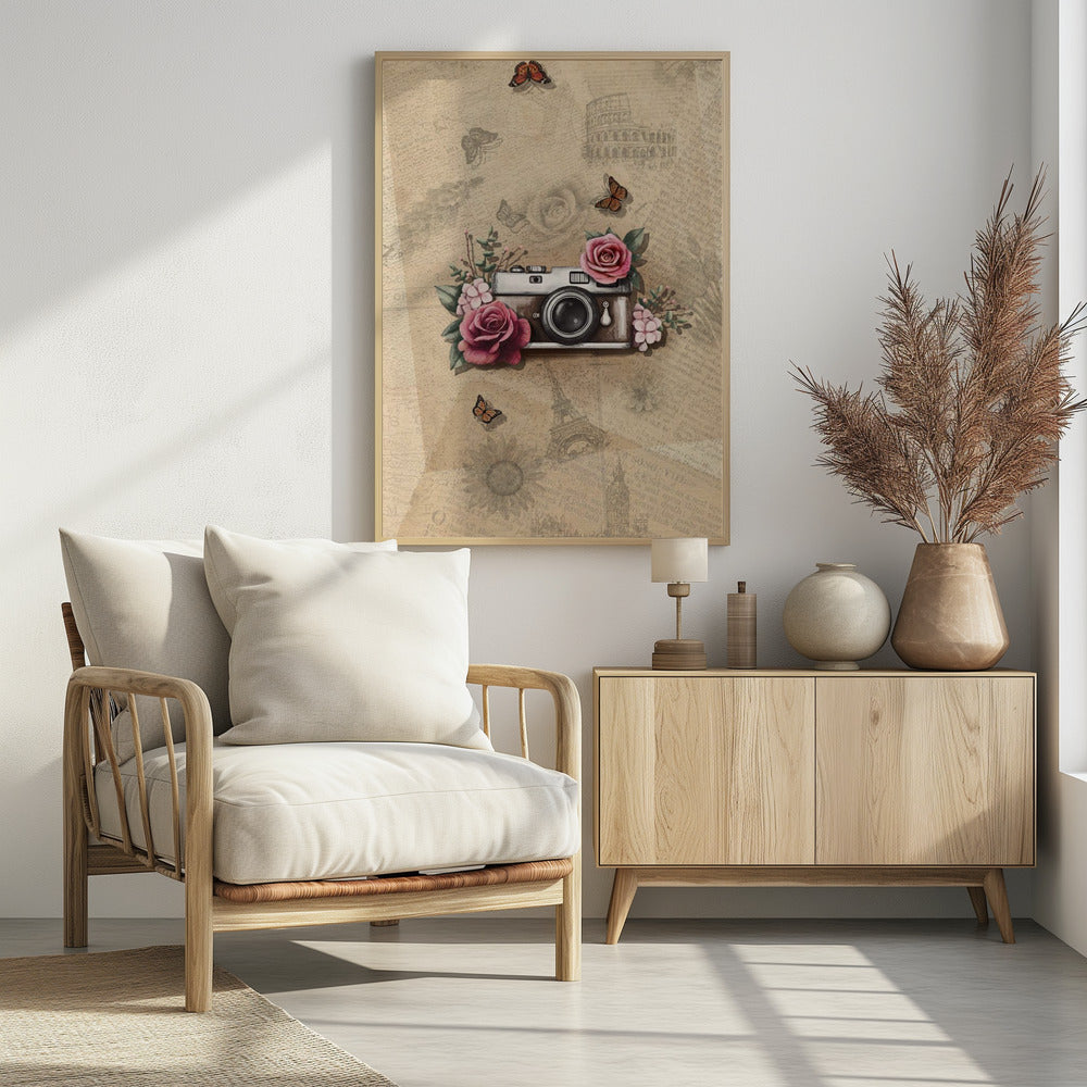 A vintage-style collage art piece in a black frame. The central focus is a retro camera adorned with pink and magenta roses and green leaves. The background is a sepia-toned collage of old newspaper or book pages, with faint illustrations of European landmarks like the Colosseum and the Eiffel Tower, along with butterflies and flowers. Poster
