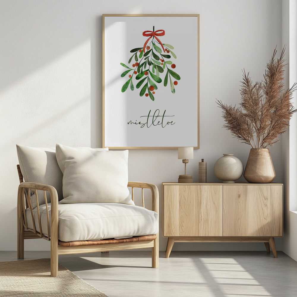 A framed watercolor illustration of a sprig of mistletoe with green leaves and red berries, tied with a red bow. Below the plant, the word 'mistletoe' is written in a cursive script on a clean white background. Artwork