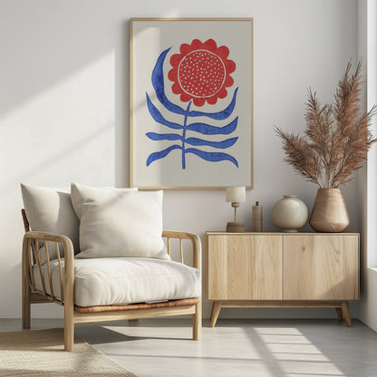 A stylized folk art painting of a flower featuring a large, round red bloom with white polka dots and bold blue leaves on a single stem. The illustration is set against a cream-colored background and enclosed in a thin black frame. Wall Art