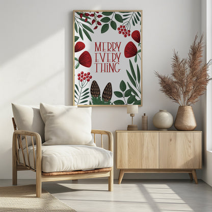 A framed holiday art print with a white background. In the center, the words 'MERRY EVERYTHING' are written in a stylized red serif font. The text is surrounded by a border of illustrated winter botanicals, including red flowers, green leaves, red berries, and brown pinecones. Print