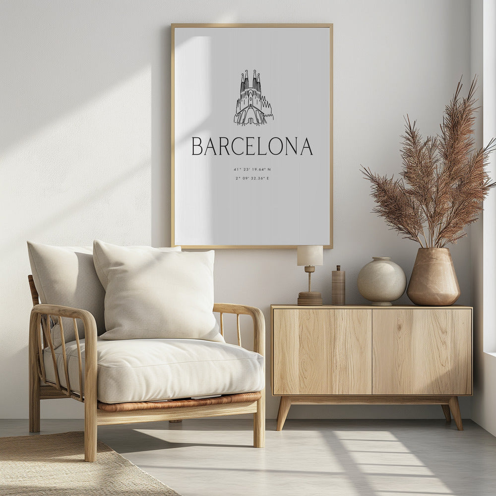 A minimalist black and white framed poster featuring a line art drawing of the Sagrada Familia. Below the drawing, the word 'BARCELONA' is printed in a large, thin sans-serif font, followed by the city's geographical coordinates. Artwork