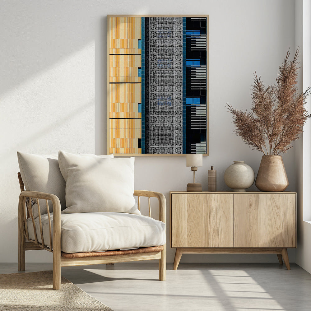 A vertical abstract architectural photograph showcasing the facade of a modern building, featuring a contrast of textures and colors: warm yellow vertical tiles on the left, an intricate white geometric screen in the center, and a dark section with vibrant blue windows on the right. Print