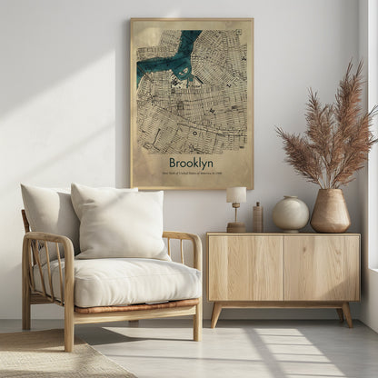 A framed vintage map poster of Brooklyn, New York from the year 1900. The map details the city's grid-like streets on an aged, beige paper background, with the waterways, including Wallabout Bay, highlighted in a vibrant teal color. The poster is titled "Brooklyn" in a dark green font at the bottom. Decor