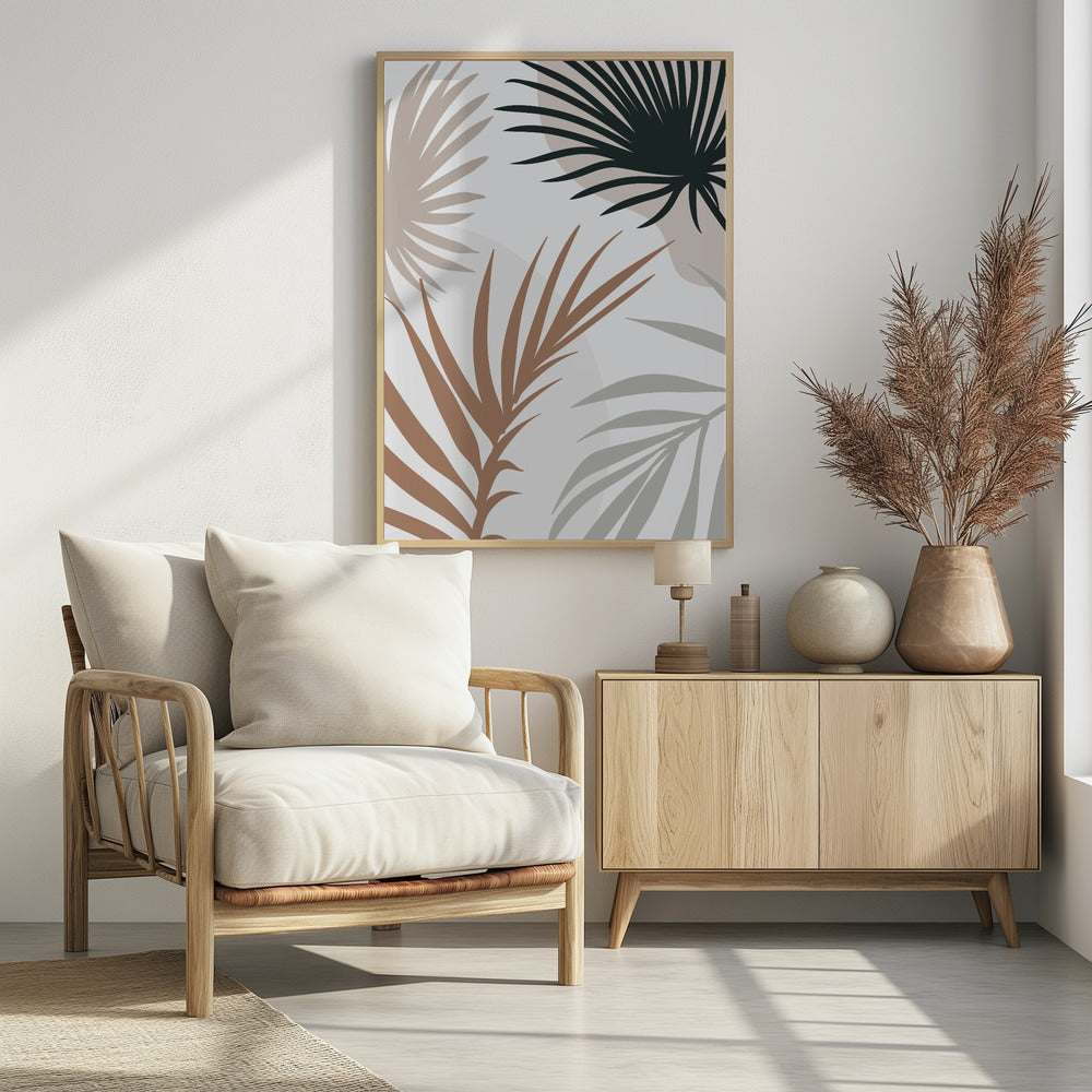 A modern art print in a black frame featuring stylized silhouettes of palm leaves. The fronds are colored in dark green, brown, beige, and light gray, overlapping on a light background with faint, large, muted pink circles. Print