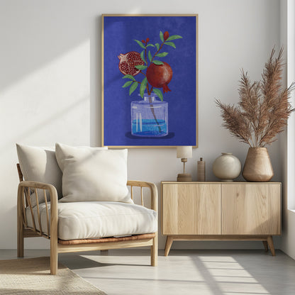 A vibrant illustration of a pomegranate branch in a clear glass vase against a deep blue, textured background. The branch features bright green leaves, a whole red pomegranate, and another cut in half to show its seeds. Decor