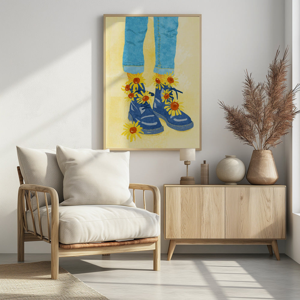 An illustration of a person's lower legs and feet wearing cuffed blue jeans and blue combat boots against a pale yellow background. Bright yellow and orange sunflowers are blooming out of the boots and laces. Poster