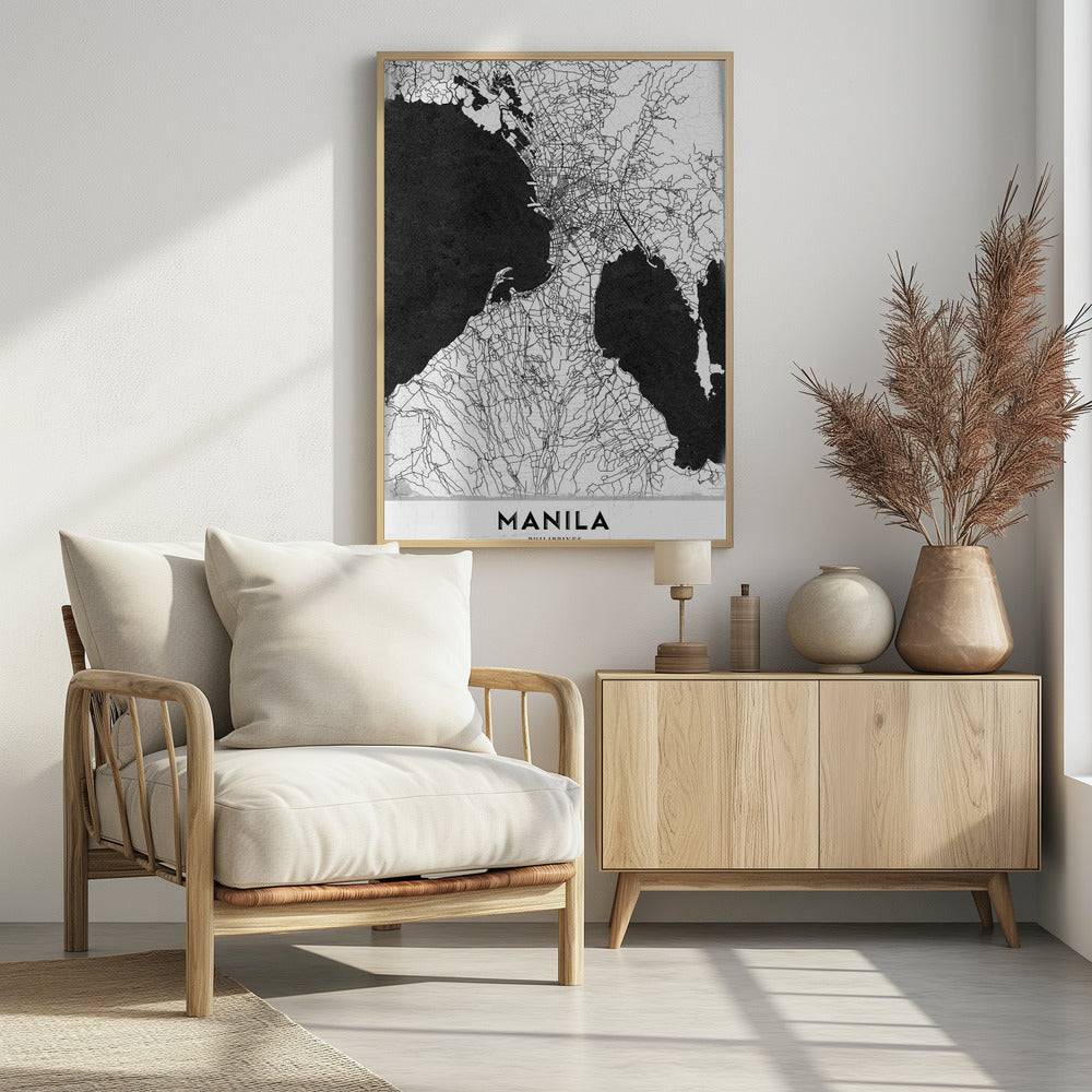 A minimalist black and white map of Manila, Philippines, presented in a black frame. The map showcases the city's intricate road network in black lines on a white landmass, contrasted against textured black bodies of water. The word 'MANILA' is printed in a bold, black sans-serif font at the bottom of the poster. Decor