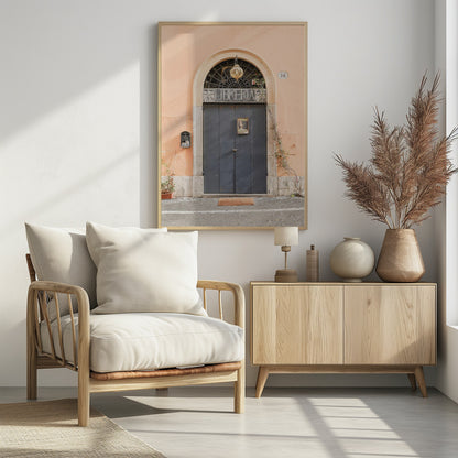 A charming European bookstore entrance featuring a large, dark grey arched door set against a peach-colored wall. Above the door, a sign reads 'LIBRERIA' below a decorative fanlight window and a hanging lantern. Decor