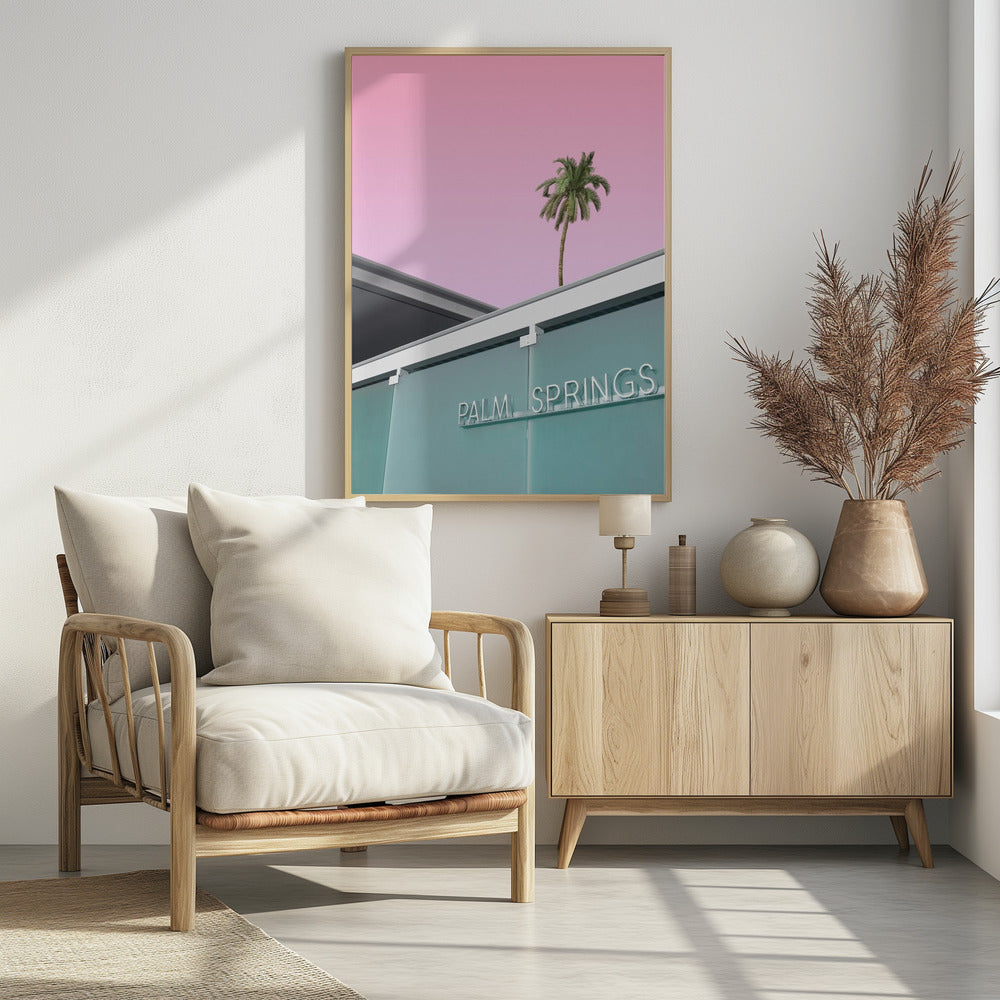 A low-angle shot of a modern building with a frosted teal glass facade and a white neon sign that reads 'PALM SPRINGS'. Above the building, a single tall palm tree stands against a solid, vibrant pink sky, creating a minimalist and stylized composition. Decor