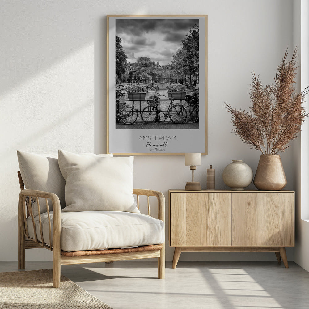 A black and white poster of the Herengracht canal in Amsterdam. In the foreground, two bicycles are parked by a railing with flower boxes. In the background, there's a classic view of the canal with a bridge, canal houses, and boats under a cloudy sky. The bottom of the poster has text that reads 'AMSTERDAM Herengracht NEDERLAND'. Decor
