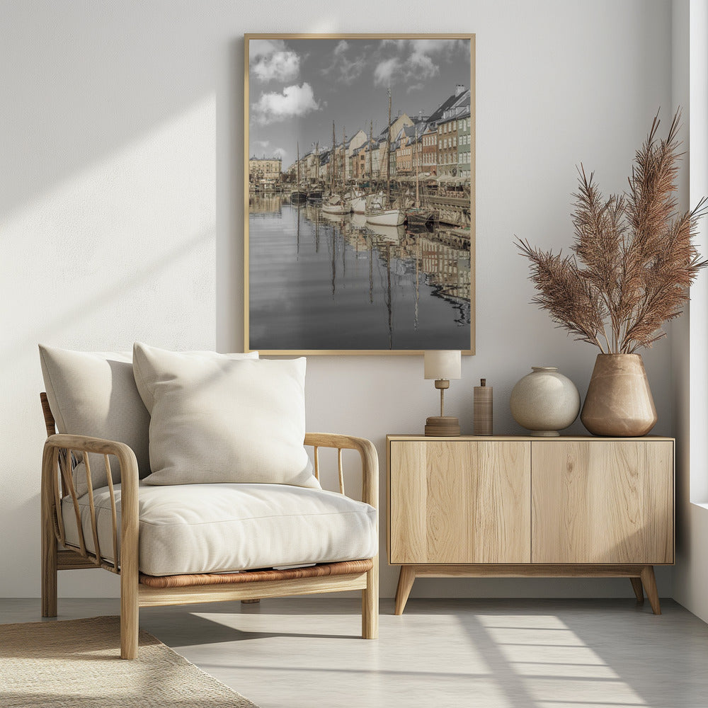 A muted, desaturated photograph of the Nyhavn harbor in Copenhagen. Old-fashioned sailboats are moored along the canal in front of a row of colorful historic buildings. The boats, buildings, and a cloudy sky are perfectly reflected in the calm water. Wall Art