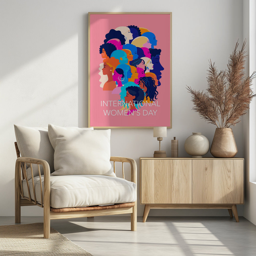 A vibrant poster for International Women's Day featuring a pink background. The central graphic is a collage of colorful profiles of diverse women, representing different ethnicities and hairstyles, all looking in the same direction. Below the illustration, white text reads 'INTERNATIONAL WOMEN'S DAY'. Wall Art