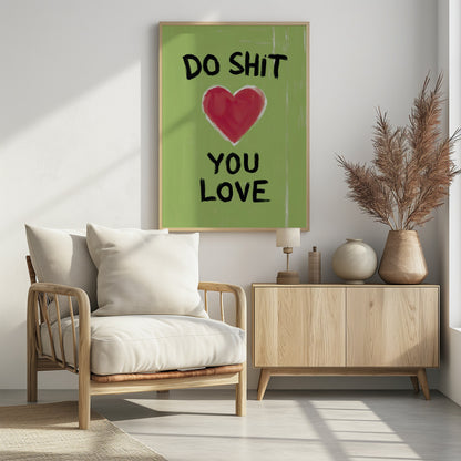 A framed modern art print with a light green background featuring the motivational phrase 'DO SHIT YOU LOVE' in black, hand-painted letters. A large, stylized red heart is painted between the top and bottom lines of text. Print