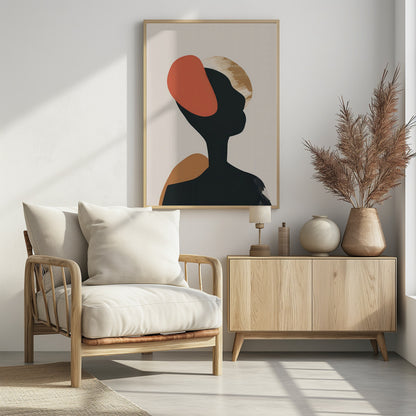 An abstract art print in a black frame featuring the silhouette of a person's head and shoulders against a light beige background. The black silhouette is overlaid with large, organic shapes in burnt orange, ochre, and a textured gold. Decor