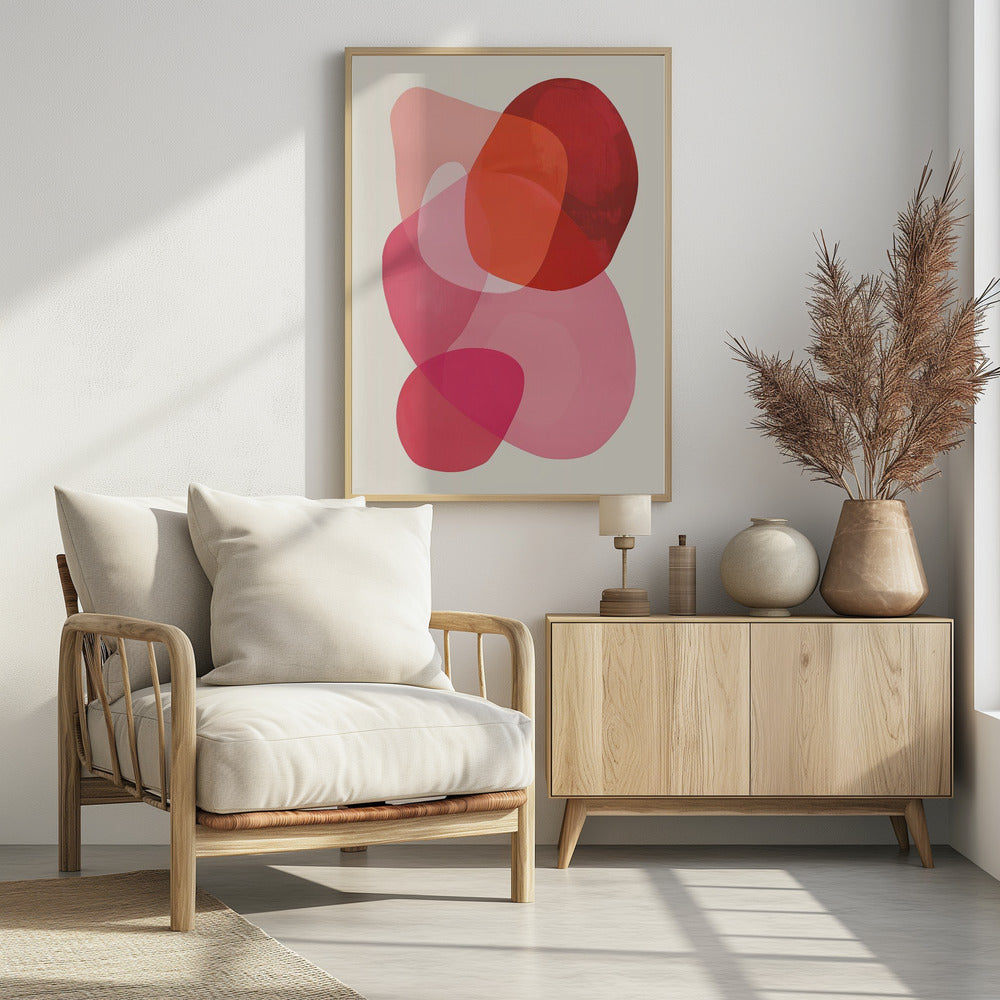 An abstract art print in a black frame, featuring a composition of overlapping, translucent, organic shapes in shades of red, orange, and pink on an off-white background. Print
