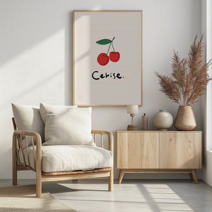 A minimalist illustration of two red cherries with a green leaf on a cream background, displayed in a black frame. The drawing is a simple continuous black line filled with color. Below the cherries, the word 'Cerise.' is written in a black, handwritten style. Poster
