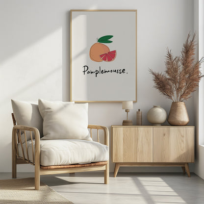 A minimalist art print featuring a stylized illustration of a whole grapefruit and a cut wedge. The fruit is peach-colored with a vibrant pink interior, topped with green leaves. Below the illustration, the French word 'Pamplemousse.' is written in a casual black script. The background is a soft off-white, and the print is enclosed in a simple black frame. Wall Art