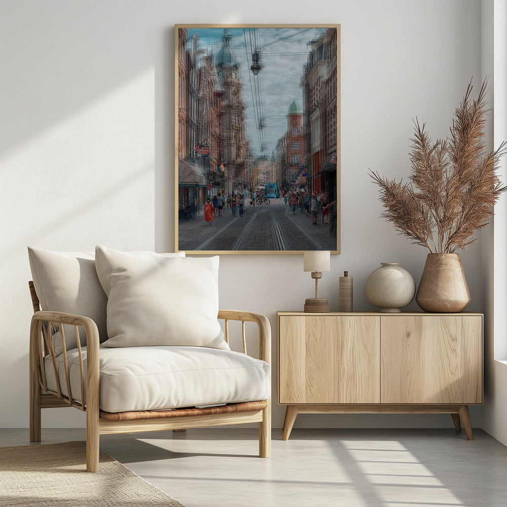 A motion-blurred, dreamlike photograph of a busy street in Amsterdam. Historic buildings line the cobblestone road, which is filled with pedestrians and features tram tracks. A prominent clock tower rises against a cloudy blue sky, and the entire scene has a shaky, layered effect. Poster