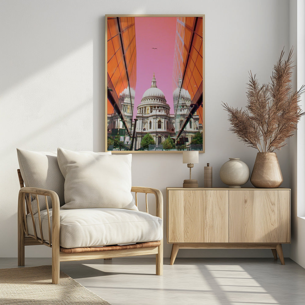 A low-angle, surrealist photograph of a classic white dome cathedral, framed perfectly between two modern orange glass buildings. The cathedral's reflection is visible on the buildings' surfaces against a vibrant, solid pink sky with a lone bird in flight. Poster