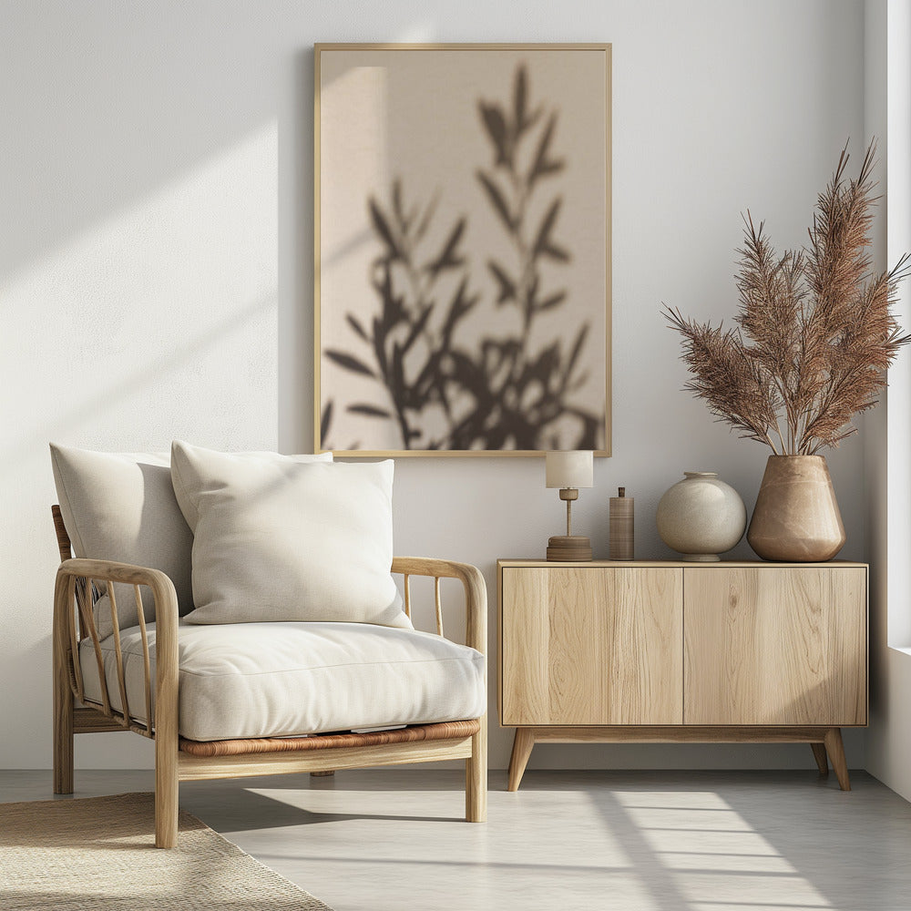 A framed photograph featuring the soft, out-of-focus shadow of a leafy plant projected onto a warm, beige-colored wall. The image has a minimalist and tranquil aesthetic, focusing on the interplay of light and shadow. Wall Art