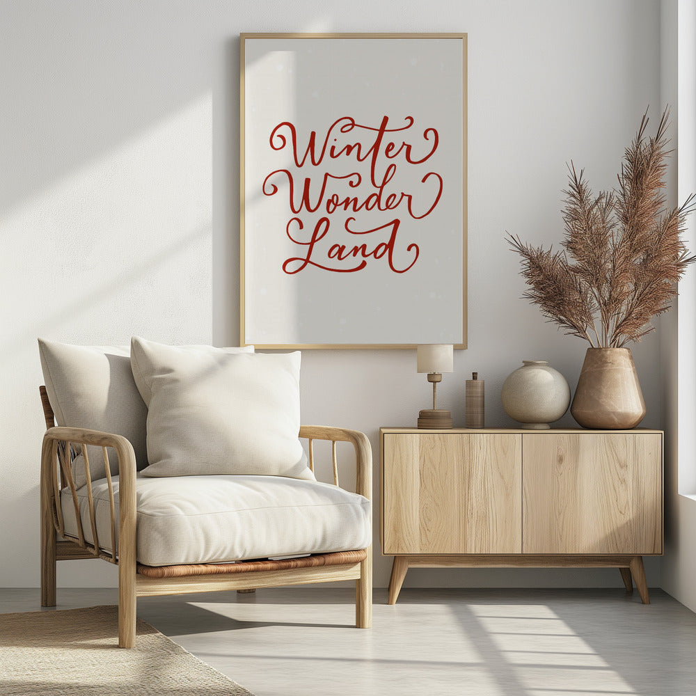 A holiday-themed art print with the words 'Winter Wonder Land' written in a flowing red script font on a speckled, off-white background, all enclosed within a simple black frame. Artwork