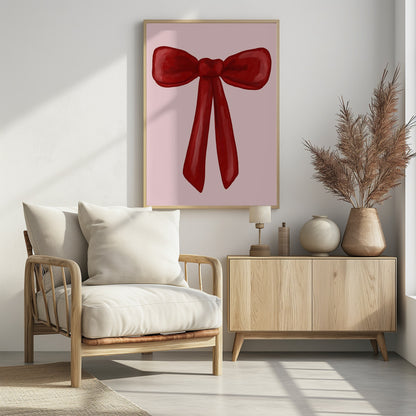 A digital painting of a large, shiny red ribbon tied into a bow, centered against a solid light pink background. The artwork is shown within a thin black frame. Print