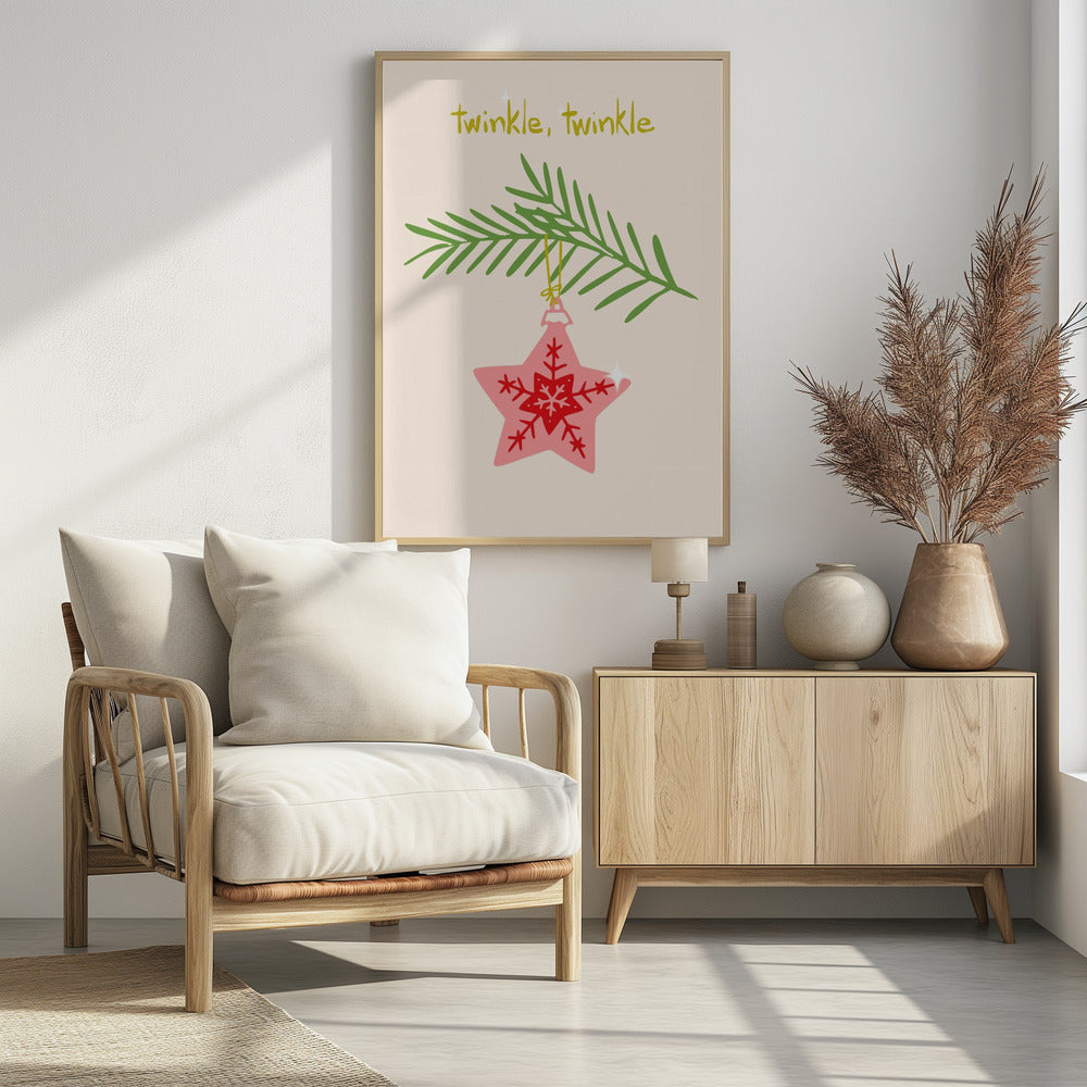 A framed piece of art with a light cream background featuring the words 'twinkle, twinkle' in a playful yellow-green font. Below the text, a pink star-shaped Christmas ornament with red snowflake designs hangs from a green pine branch. Print