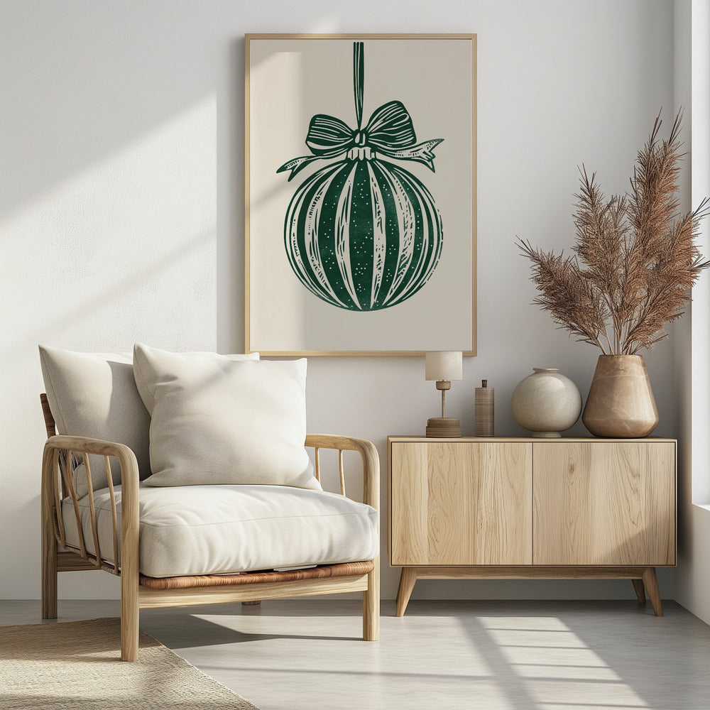 A vintage-style linocut print of a dark green Christmas bauble with a large bow, hanging against a cream background. The ornament features vertical stripes and white speckles, and the entire artwork is presented in a simple black frame. Artwork