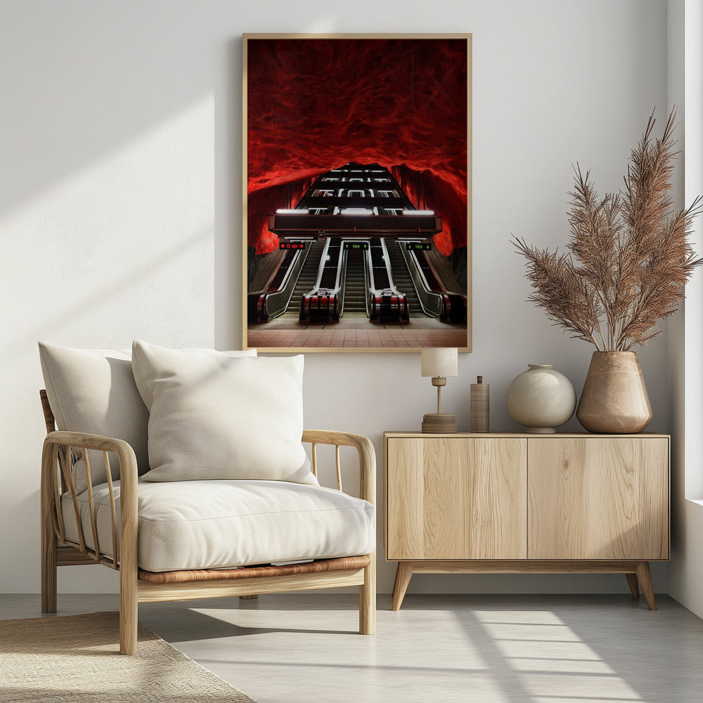 A dramatic low-angle shot looking up a series of escalators in a subway station with a cavernous, rough-textured ceiling glowing an intense, fiery red. Decor