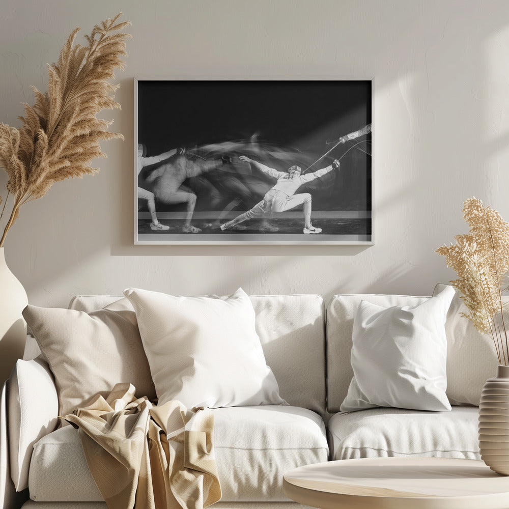 A framed, dramatic black and white photograph using long exposure to capture a fencer in motion. The fencer, in full white gear, lunges forward, their form crisp at the end of the movement while a ghostly blur trails behind, illustrating their rapid advance against a black background. Decor