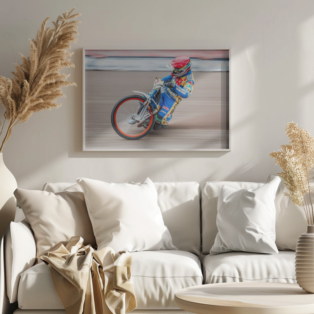 A speedway motorcycle racer in a blue and yellow suit with a red helmet leans sharply into a turn on a dirt track, with motion blur in the background conveying a sense of high speed. Print