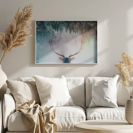A surreal double-exposure artwork featuring the back of a deer's head with large antlers, blended with an image of a misty pine forest. The forest is reflected above the antlers against a soft, pastel-colored background, all enclosed in a silver frame. Print