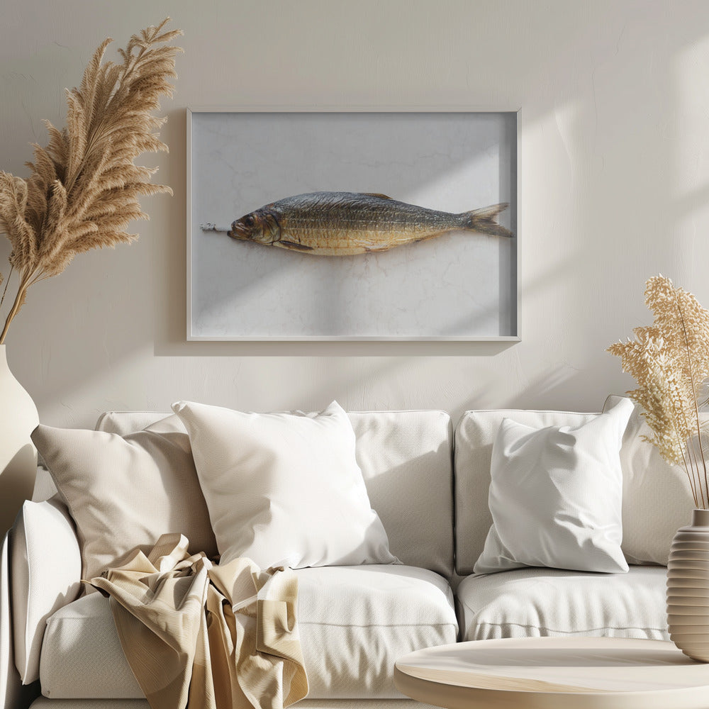A surreal photograph of a whole smoked fish with a cigarette butt in its mouth, laying horizontally on a white marble surface, all within a silver frame. Wall Art