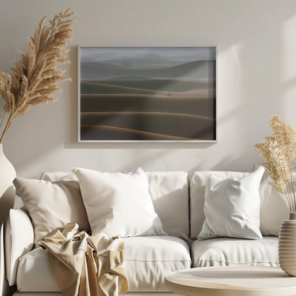 A framed photograph of a serene desert landscape, with layers of rolling sand dunes creating a sense of depth. Dark brown dunes in the foreground give way to lighter, hazy dunes and hills in the misty background. Print