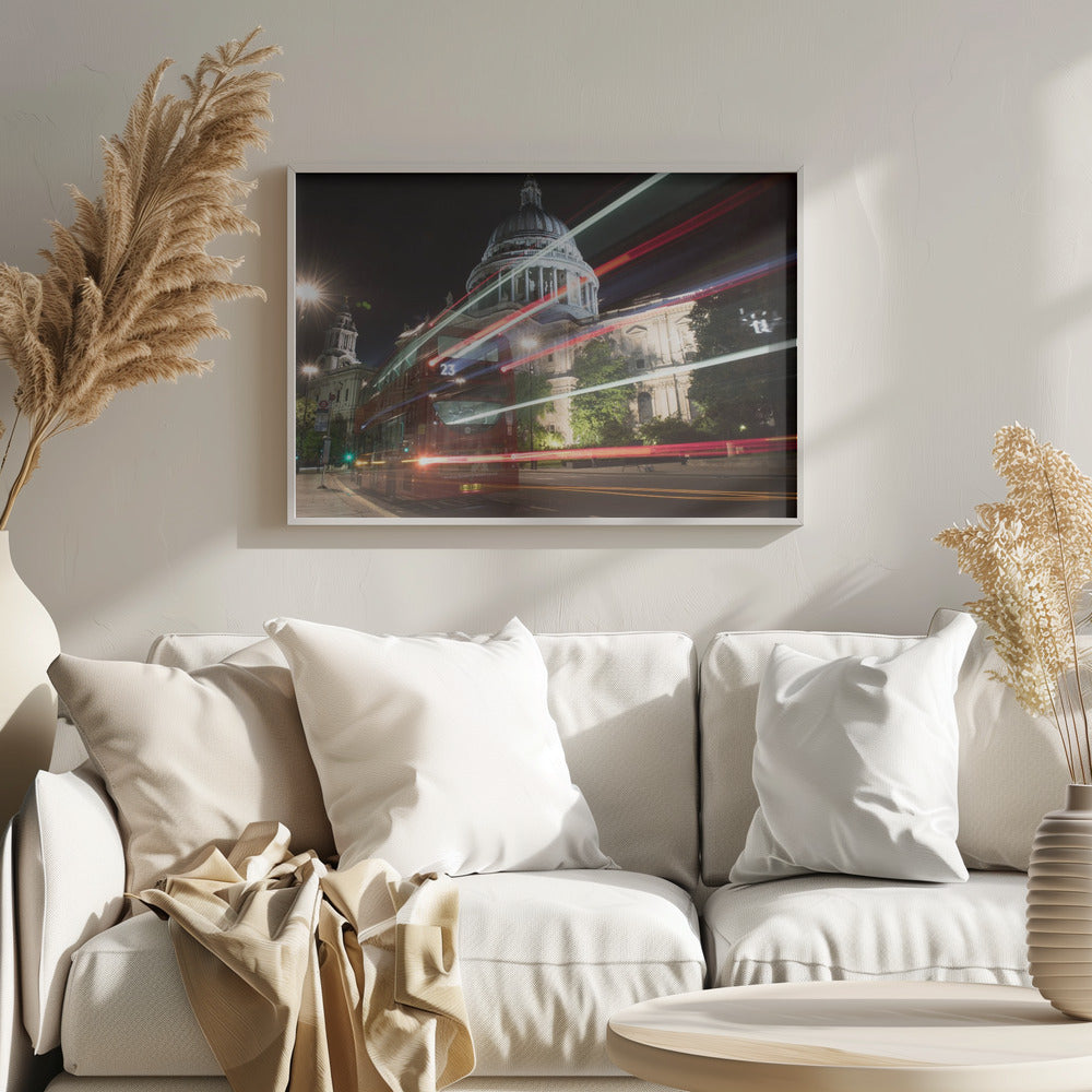 A long-exposure night photograph of a red double-decker bus in London, creating vibrant red and white light trails in front of the illuminated St. Paul's Cathedral. Decor