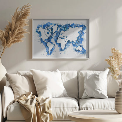 An abstract watercolor world map in a silver frame. The continents are depicted in white negative space, while the oceans are represented by vibrant blue splashes, splatters, and drips of paint on a white background. Artwork