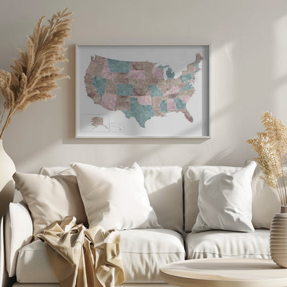 A stylized map of the United States in a silver frame. The states are colored with a marbled texture in alternating shades of muted brown, dusty pink, and teal. Each state is labeled, and the words 'UNITED STATES' are spaced across the country. Insets for Alaska and Hawaii are in the bottom left corner. Artwork