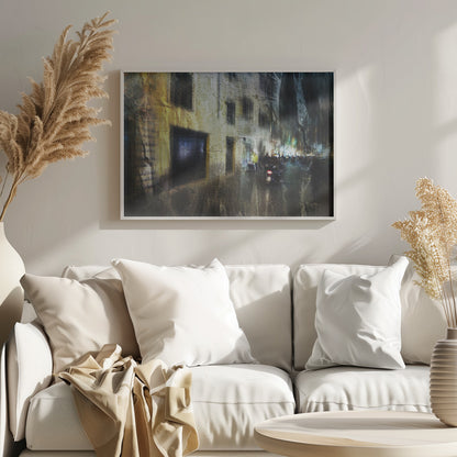 A framed abstract digital artwork depicting a busy, narrow city street at night. The image has a heavily textured, painterly style, with blurred motion effects. A weathered, yellow-lit building is on the left, while the street on the right is filled with indistinct figures of people and a motorcycle, with city lights glowing in the distance. Wall Art