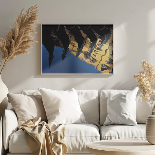 An abstract photograph of a distorted reflection in water, showing a vibrant yellow building against a deep blue sky, with the dark silhouettes of several Venetian gondola prows cutting across the top of the image. The entire scene is enclosed in a silver picture frame. Print