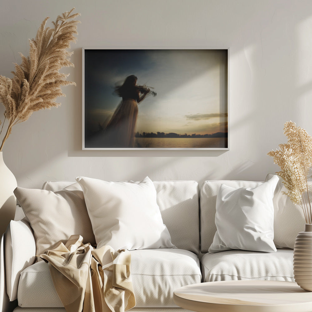 An artistic, framed photograph with motion blur capturing the silhouette of a woman in a long flowing skirt playing the violin by a lake against a dramatic sunset sky. Poster