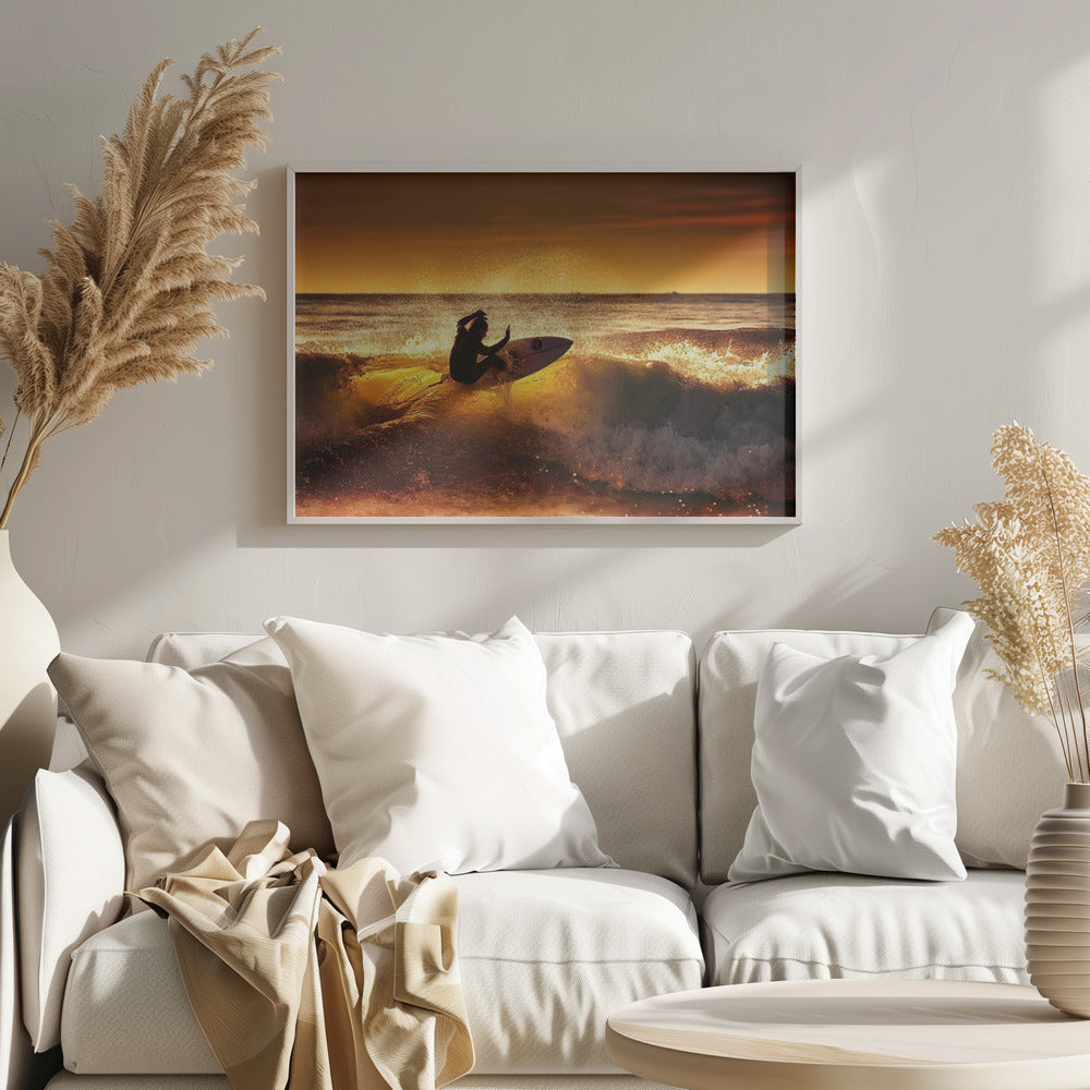 A silhouetted surfer carves a turn on a sun-kissed wave during a vibrant orange sunset, with golden light reflecting off the water and sea spray. Wall Art