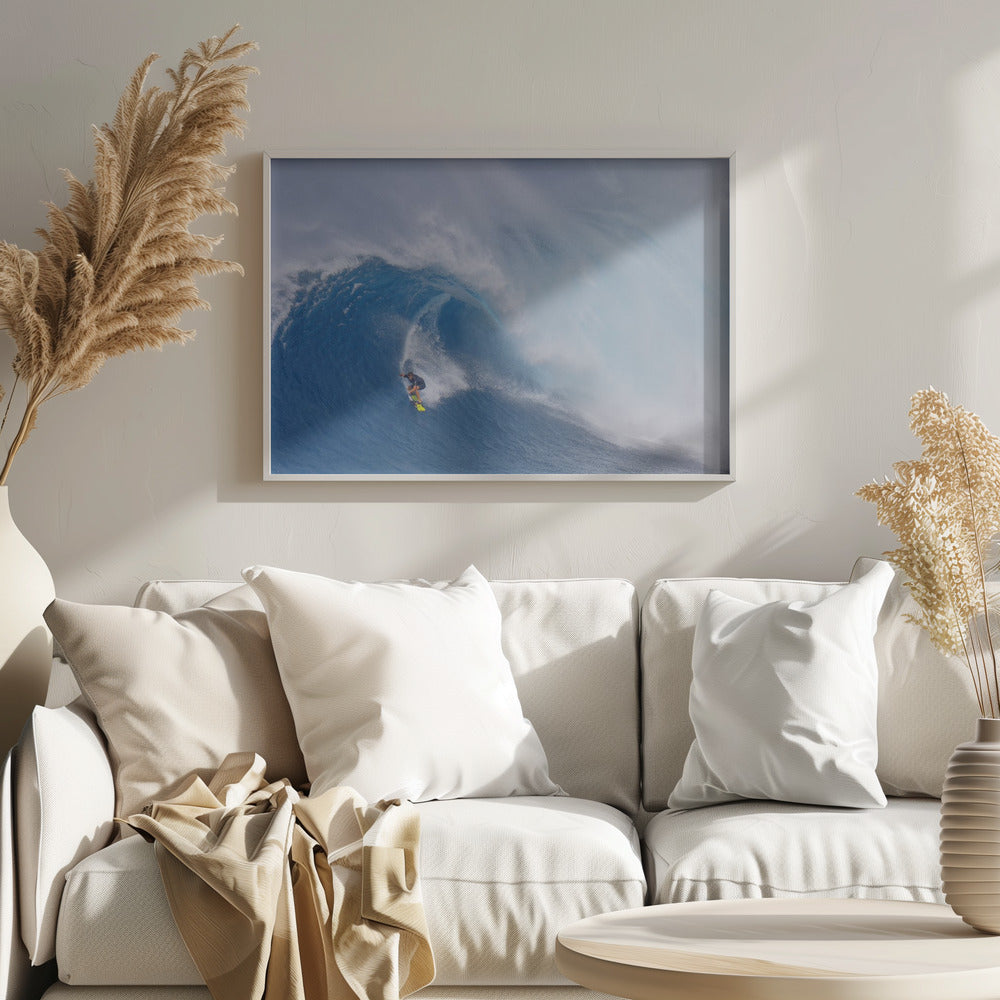 A framed photograph of a professional surfer skillfully riding down the steep face of a massive, cresting blue ocean wave, surrounded by white sea spray. Decor