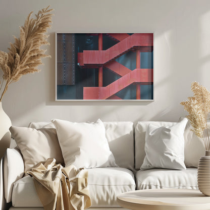 A framed abstract architectural photograph of a bright red industrial staircase zig-zagging against a dark teal wall. The composition highlights the geometric shapes and bold color contrast between the red stairs and the cool-toned background, with a silver mesh panel visible on the left side. Print