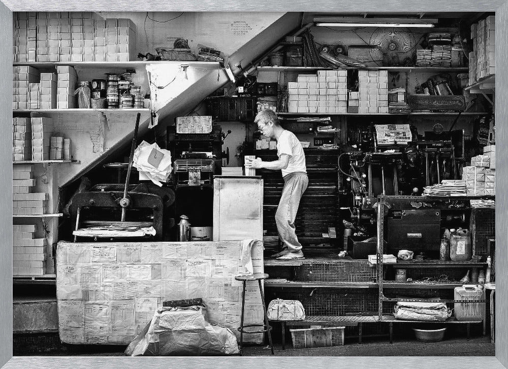 A vintage art print depicting a small, old-fashioned printing shop interior, showcasing antique machinery and a nostalgic atmosphere. Artwork