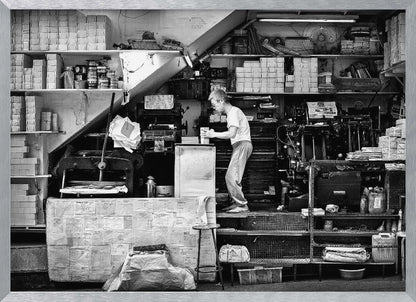 A vintage art print depicting a small, old-fashioned printing shop interior, showcasing antique machinery and a nostalgic atmosphere. Artwork