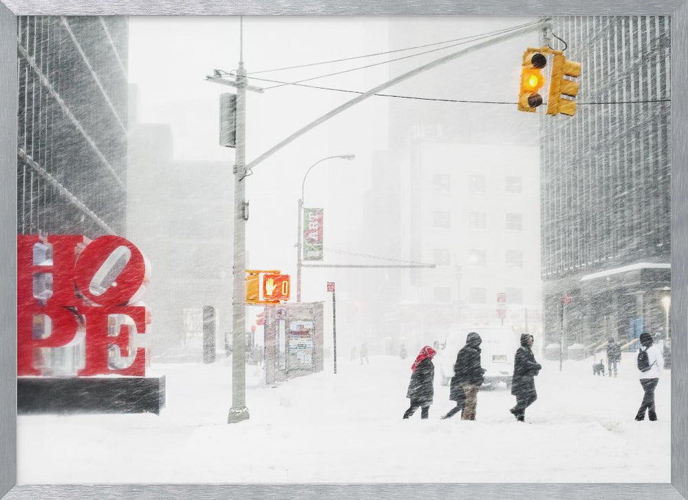 A photograph of a busy city street during a heavy snowstorm. In the foreground on the left, a large, bright red sculpture spells out the word 'HOPE', providing a stark contrast to the muted, white, and gray tones of the snowy scene. Pedestrians in winter coats are crossing the snow-covered street, and tall buildings are partially obscured by the falling snow in the background. Wall Art
