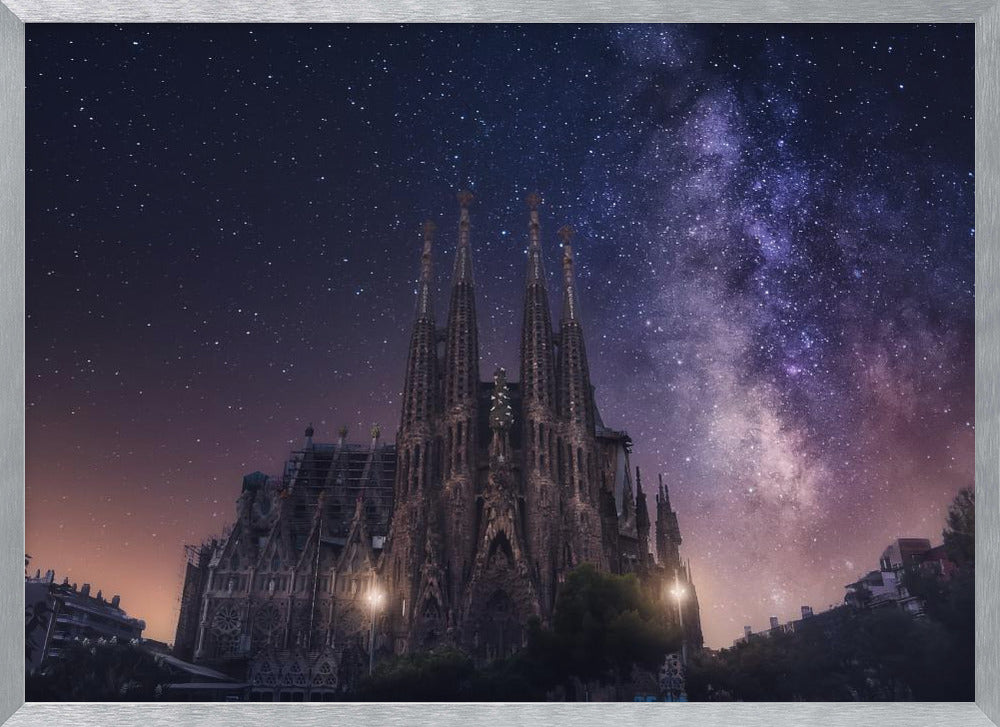 A fantastical night view of the Sagrada Familia in Barcelona, its intricate spires reaching up towards a magnificent, starry sky filled with the purple and pink hues of the Milky Way galaxy, all enclosed in a silver frame. Artwork