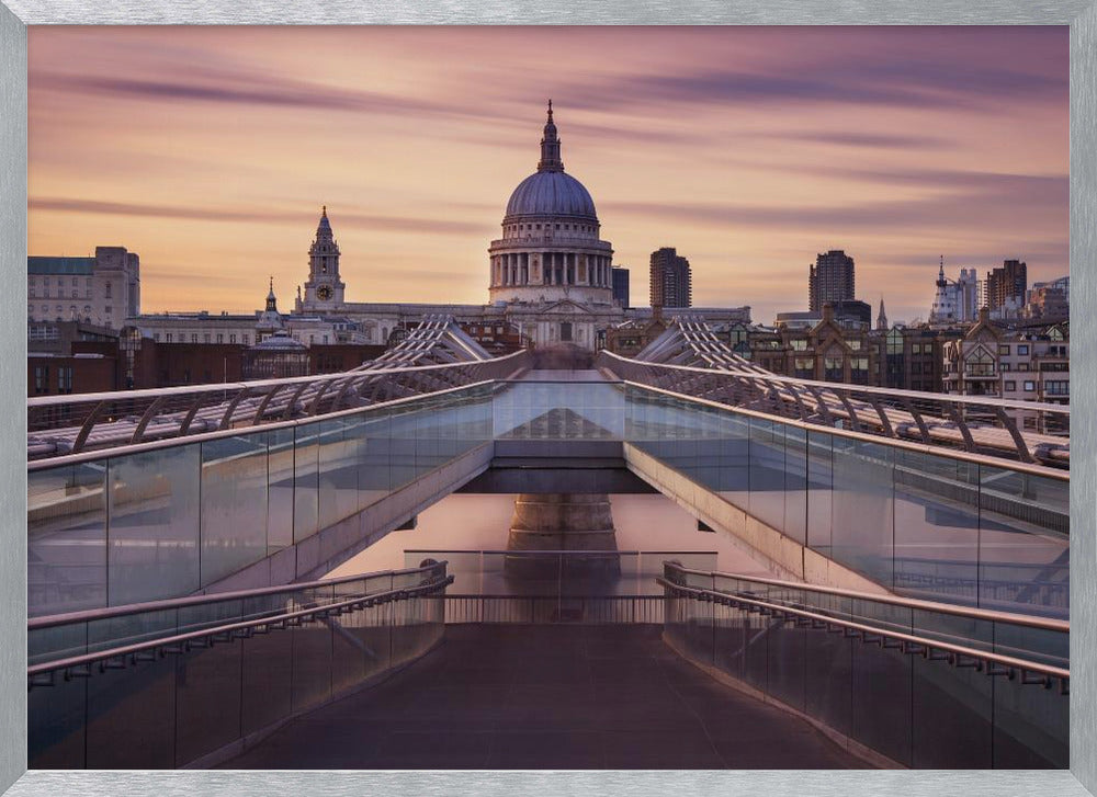 A photograph looking down the center of the Millennium Bridge in London, leading the eye directly to St. Paul's Cathedral, which is centered in the background under a beautiful purple and orange sunset sky. Print