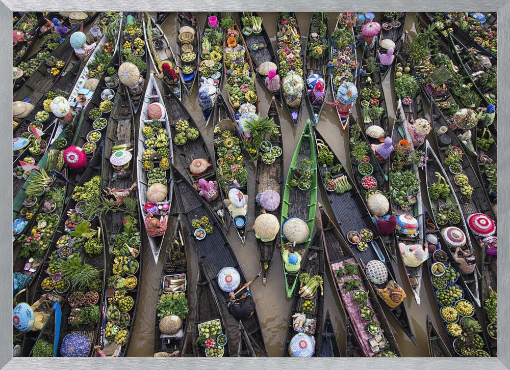 An aerial photograph of a crowded floating market in Southeast Asia, with dozens of narrow wooden boats filled with vibrant green produce and colorful wares on a brown river. Poster