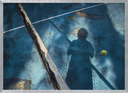 An artistic, high-angle shot of a weathered blue tennis court. The shadow of a tennis player holding a racket is cast across the court, with a yellow tennis ball suspended in mid-air nearby. A tattered tennis net runs diagonally across the frame, all enclosed within a silver border. Wall Art
